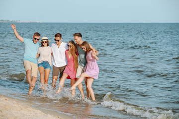 Happy friends on sea beach at resort