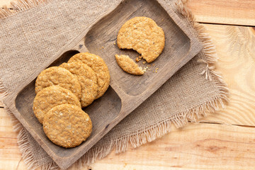 Homemade oat and wholemeal biscuits  on brown wooden tray. Its are a nutrient-rich food associated with protein, fiber and no artificial flavours or colour added.