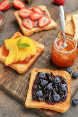 Different tasty sandwiches on wooden board, closeup