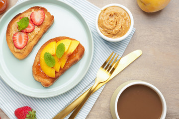 Plate with tasty sandwiches and cup of coffee on table
