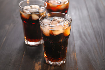 Glasses of cold cola on wooden table