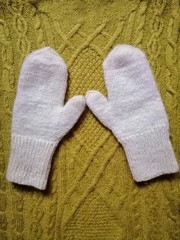 white mittens on the background of a winter sweater