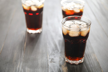 Glasses of cold cola on wooden table