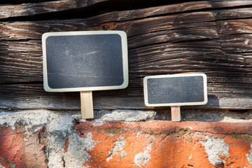 An information sign stands on a brick and wooden obsolete wall