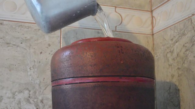 person filling filtered water on a Ceramic clay filter, typical Brazilian way of filtering water