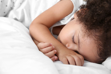 Fototapeta na wymiar Little African-American girl sleeping in bed