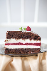 A piece of chocolate brownie cake with vanilla mousse and raspberry jelly.  Homemade