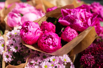 Freshly picked bouquet of peony flowers on display at the farmers market. Pink peonies for sale in floral shop © mdyn