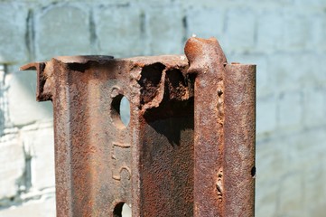 Old rusty post made of iron rails