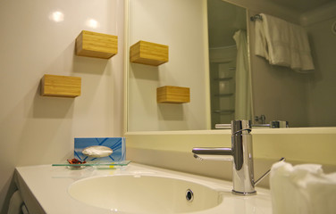 Waschbecken mit Wasserhahn und Regalen in Badezimmer auf Kreuzfahrtschiff