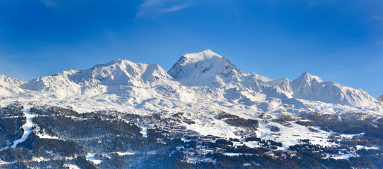 view on peak mountain covered with snow in winter above ski resort in european alps