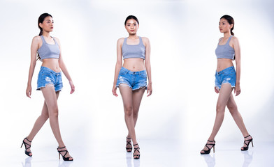 Obraz premium Full Length Snap Figure step of Fashion Business Asian Woman Tan skin black hair wear vast walk with short jean pants legs high heels shoes. Studio Lighting white Background isolated copy space