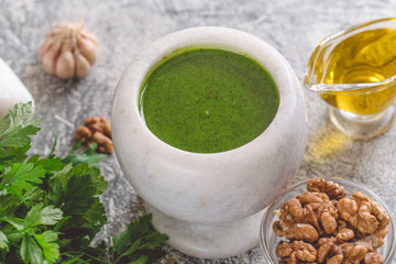 Homemade parsley pesto sauce and ingredients. Vegan healthy food.