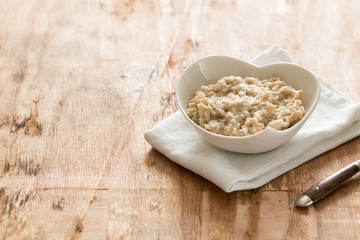 white Bowl of oats porridge. Healthy oatmeal breakfast
