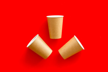 Empty paper cups for coffee to-go from cafe on red background top view