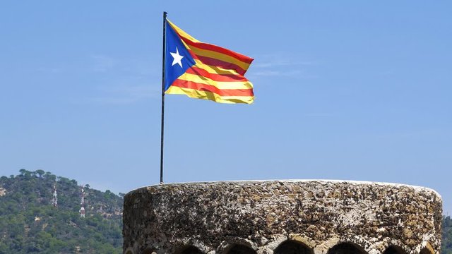 Waving flag of Catalonia on an old tower.