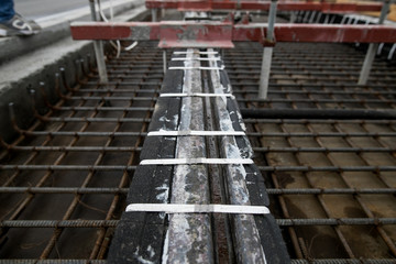 Fototapeta premium Repair of the railway tram line. Installation of new modern silent railway rails for trams. Laying of stone paving, road paving slabs on street. Repair of reconstruction of city roads with a tram line