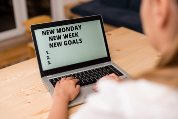 Conceptual hand writing showing New Monday New Week New Goals. Concept meaning showcasing next week resolutions To do list woman with laptop smartphone and office supplies technology