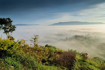 Mountain view morning of forest and top hill around with ocean of mist with cloudy sky background,...