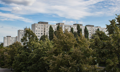 Fototapeta na wymiar Concrete block of flats and cloudy sky in the Gazdagrét neighbourhood of Budapest, Hungary, Europe. Residential area consisting of prefabricated buildings in the western part of the 11th district.