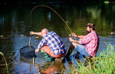 Trap for fish. Men sit at riverside with fishing equipment. Illegal hunting caviar. Extracts eggs...