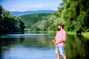 Fototapeta na wymiar Environmental impact of fishing includes issues such as availability of fish. Man at riverside enjoy idyllic landscape while fishing. Fishing cause negative physiological effects for fish populations