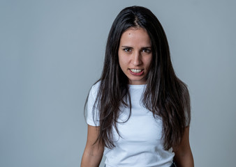 Fototapeta premium Portrait of beautiful young latin woman with angry and furious face. Human expressions and emotions
