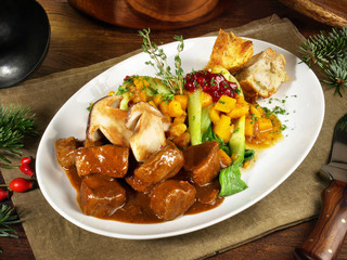 Hirschgulasch mit Steinpilze, Gemüse und Semmelknödel