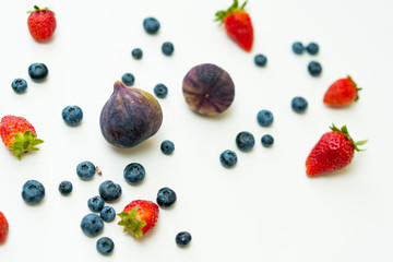 Figs, blueberries and strawberries flat lay background.