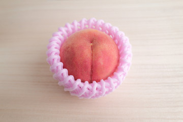 フルーツ・ギフト・お中元イメージ素材：ピンク色のフルーツキャップで保護されたかわいい白桃