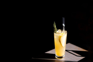 Pear lemonade on an iron table with amazing light and deep black background.