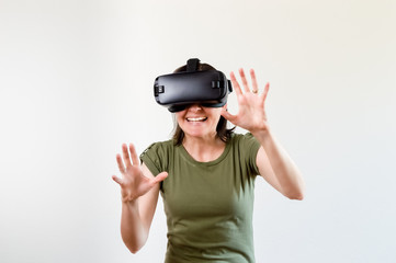 Brunette woman exploring modern technology virtual reality with head mounted display on white background