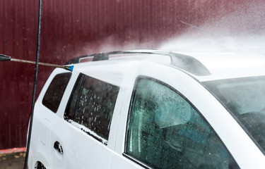 The process of washing a white car using a pressure washer