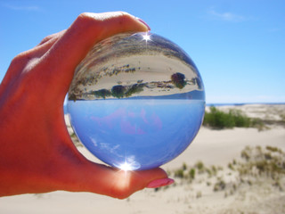 Glass ball on the background of the dune of Efa