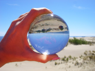 Glass ball on the background of the dune of Efa
