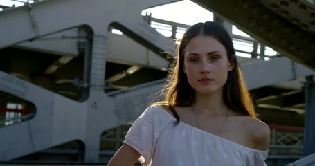 alone sad woman is leaning handrail of big bridge in town in sunny day
