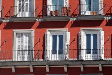Fachada roja con persianas blancas en la plaza Mayor de Madrid