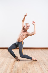 Fototapeta na wymiar Beautiful male ballett dancer performing indoor