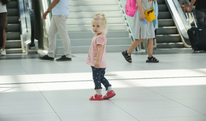 Child lost at the airport or shopping mall, little girl looking for her parents