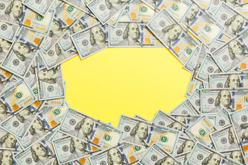 Frame of one hundred dollar bills with empty space for your design. Top view of business concept on yellow background with copy space