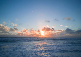 people are playing surf board in blue sea with sunset,in scarborough beach western australia