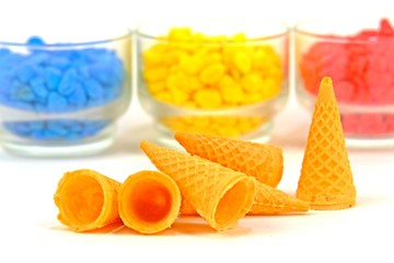 Ice cream cones freely put on white floor having colorful stones as background.