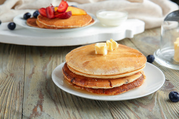 Tasty pancakes with butter on wooden table