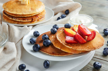 Tasty pancakes with berries on wooden table