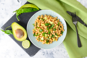 Plate with tasty chickpea salad on table