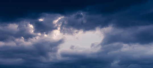 Blue hour sky clouds background. Beautiful landscape with stormy clouds and purple sun on sky