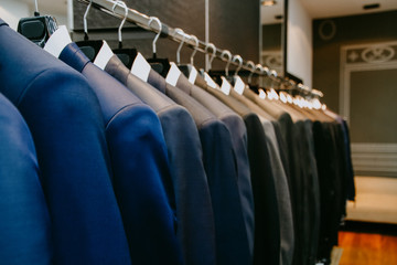 Men suit jackets on hanger in a shop