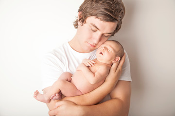 New teen father proudly holding his new born baby girl