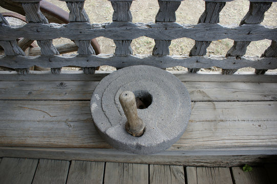 The ancient quern stone hand mill. vintage wheat grain grinder, close-up. Farming and agriculture concept