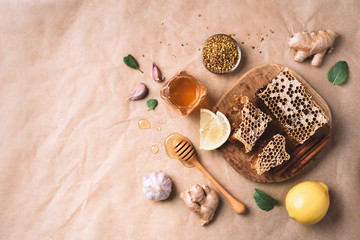 Ingredients for healthy hot drink. Lemon, ginger, mint, honey, apple and spices on craft paper background. Copy space. Top view. Alternative medicine concept. Clean eating, detox